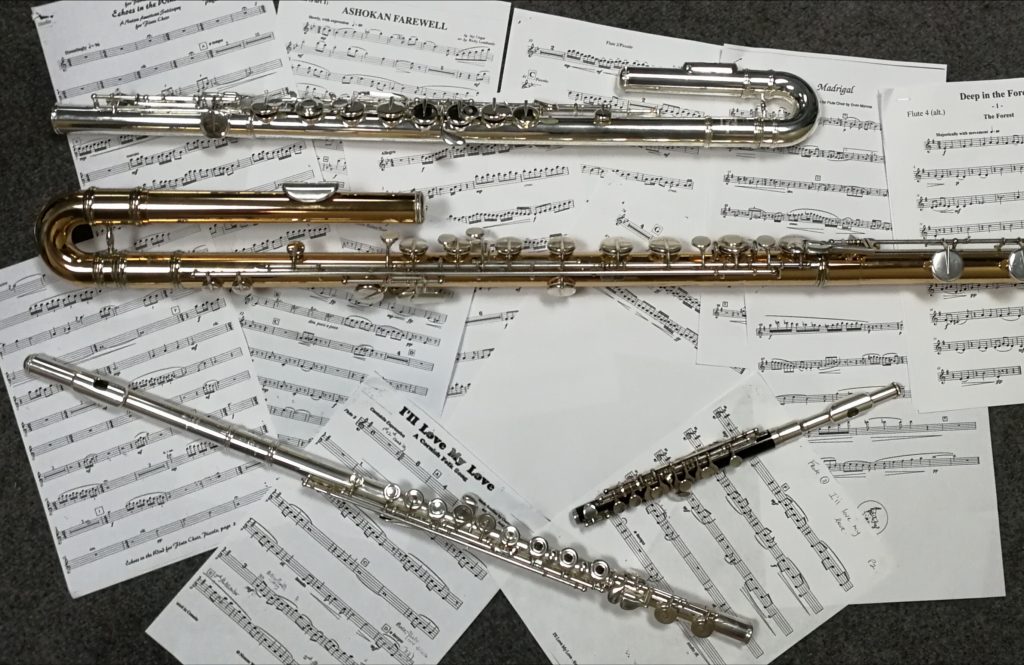 a piccolo, c flute, alto flute and bass flute on music